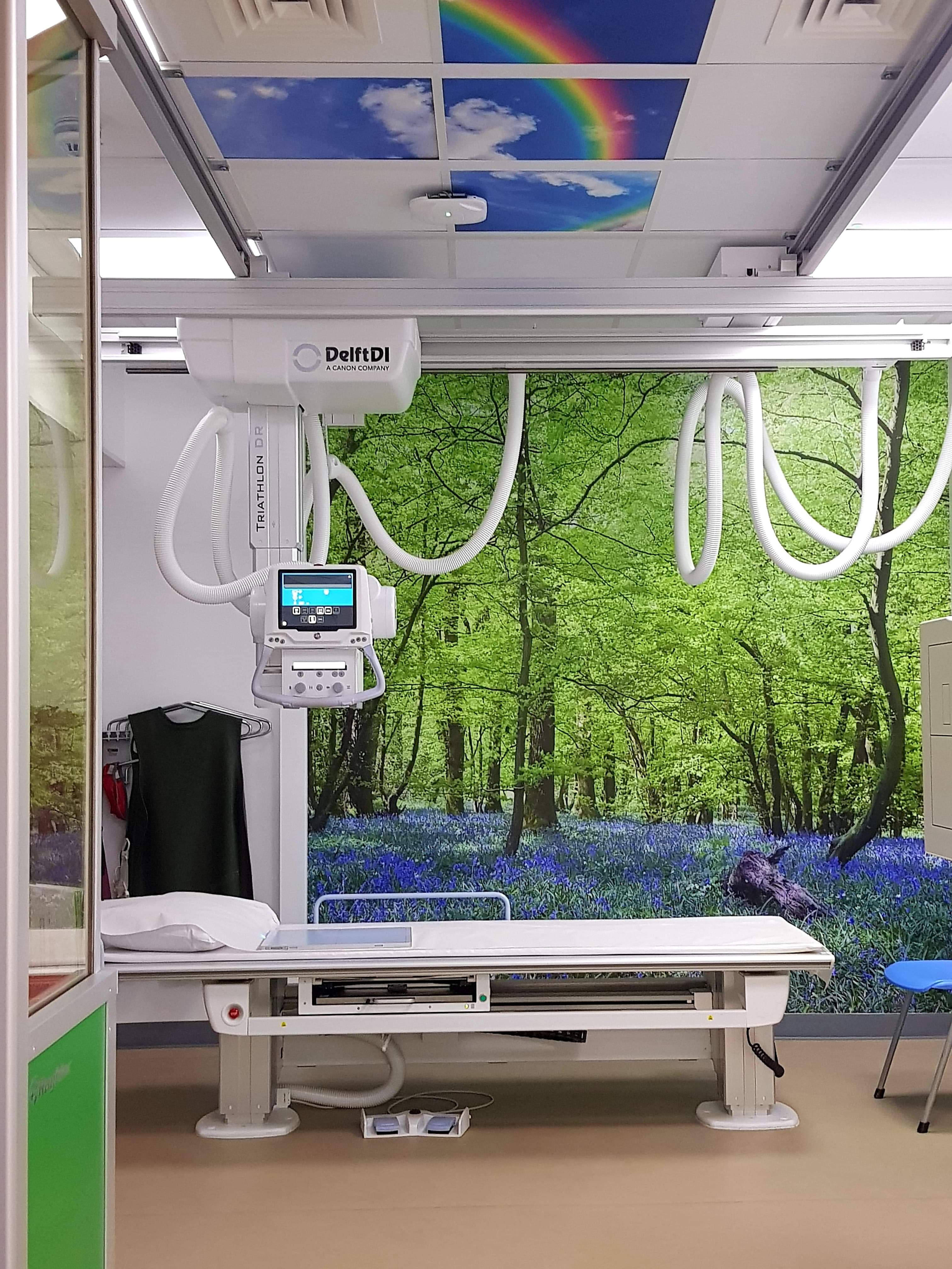 Dementia-friendly x-ray room with woodland imagery and blue sky tiles