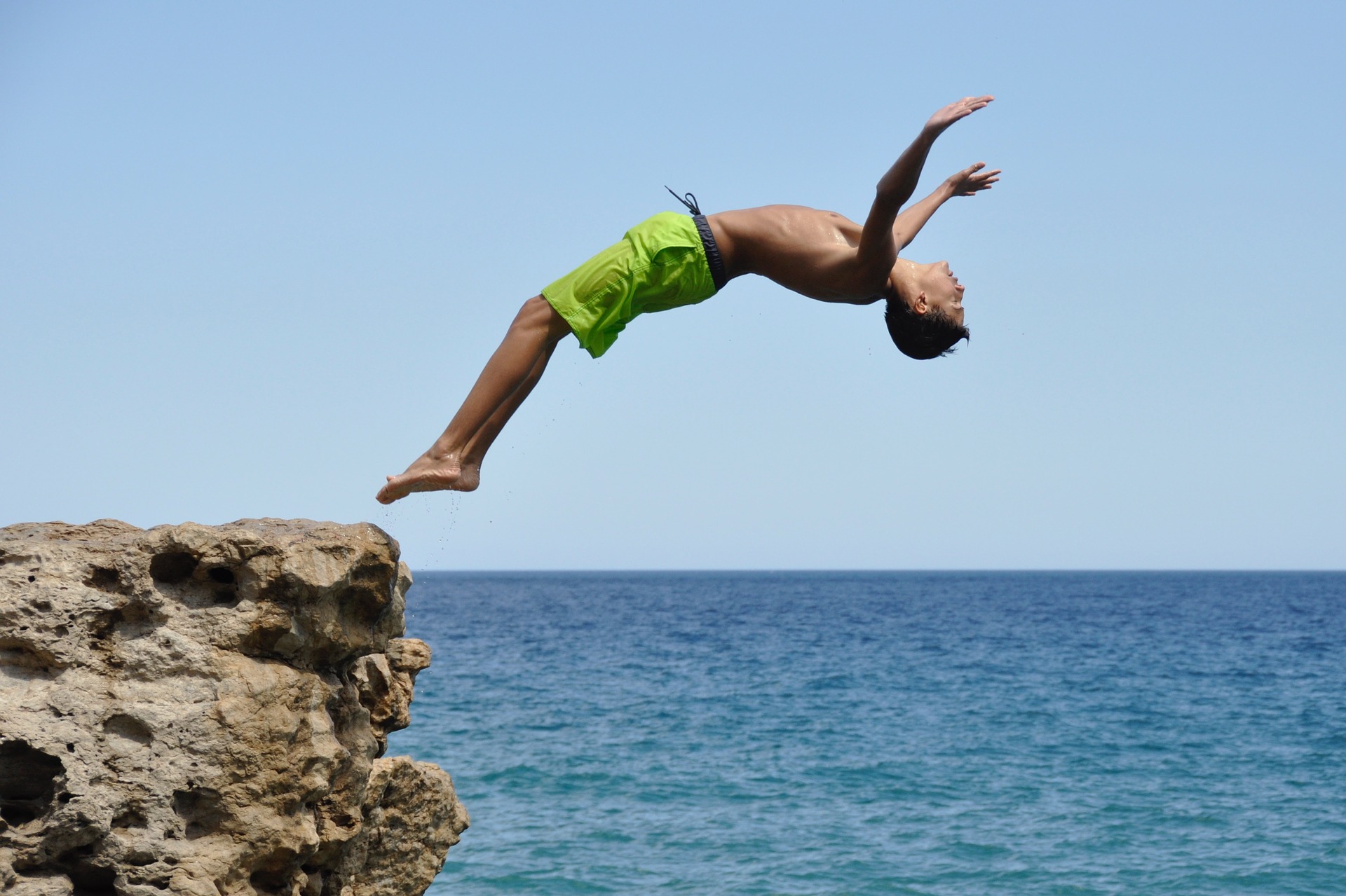 Boy diving off rocks