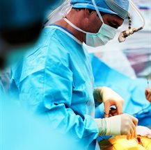 Surgeon in blue scrubs performing an operation