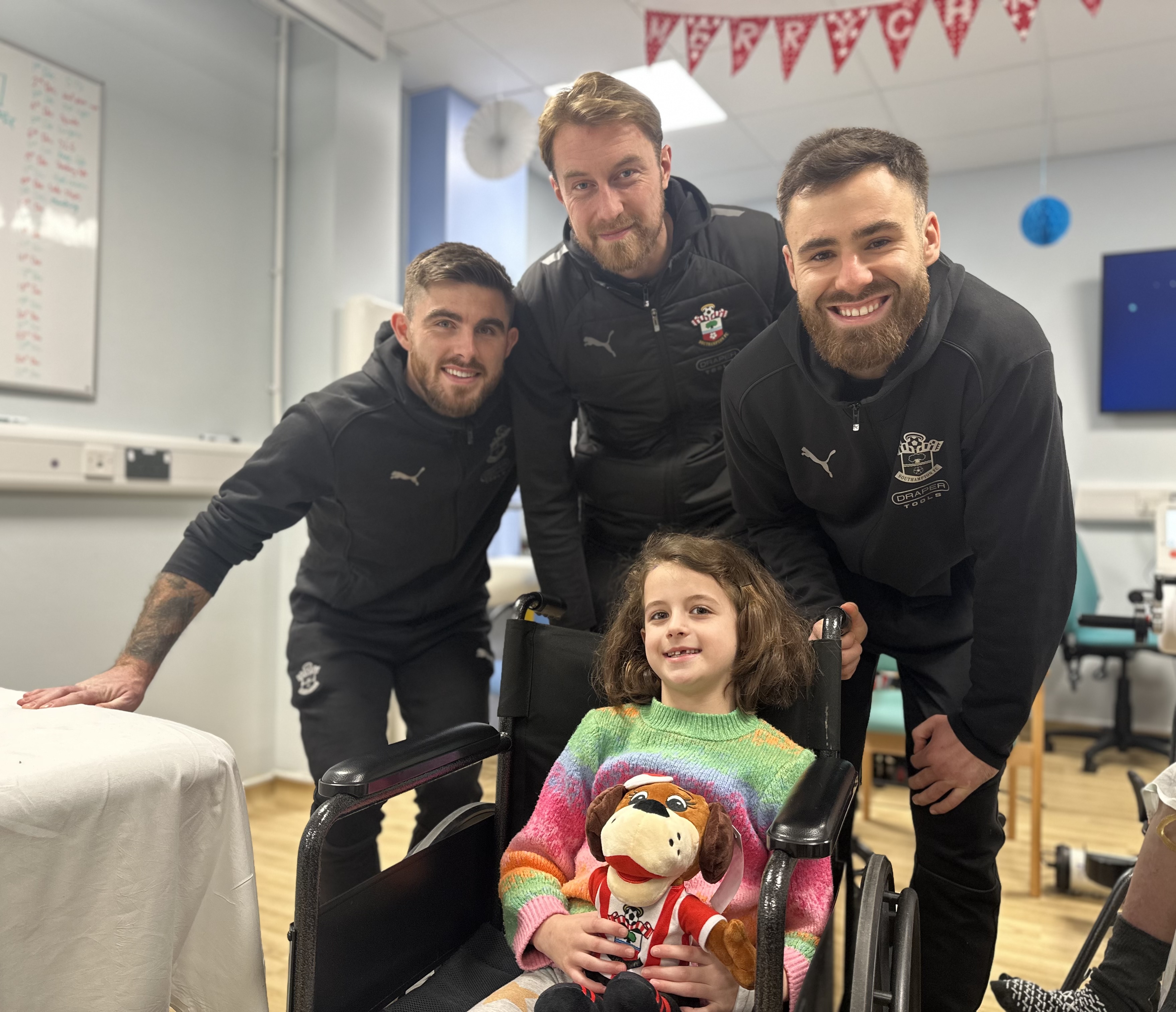 Saints players with Alaia Matthews in the children's hospital