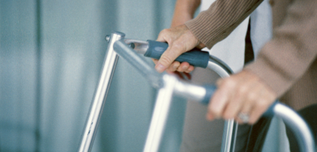 Hands holding on to a walking frame.