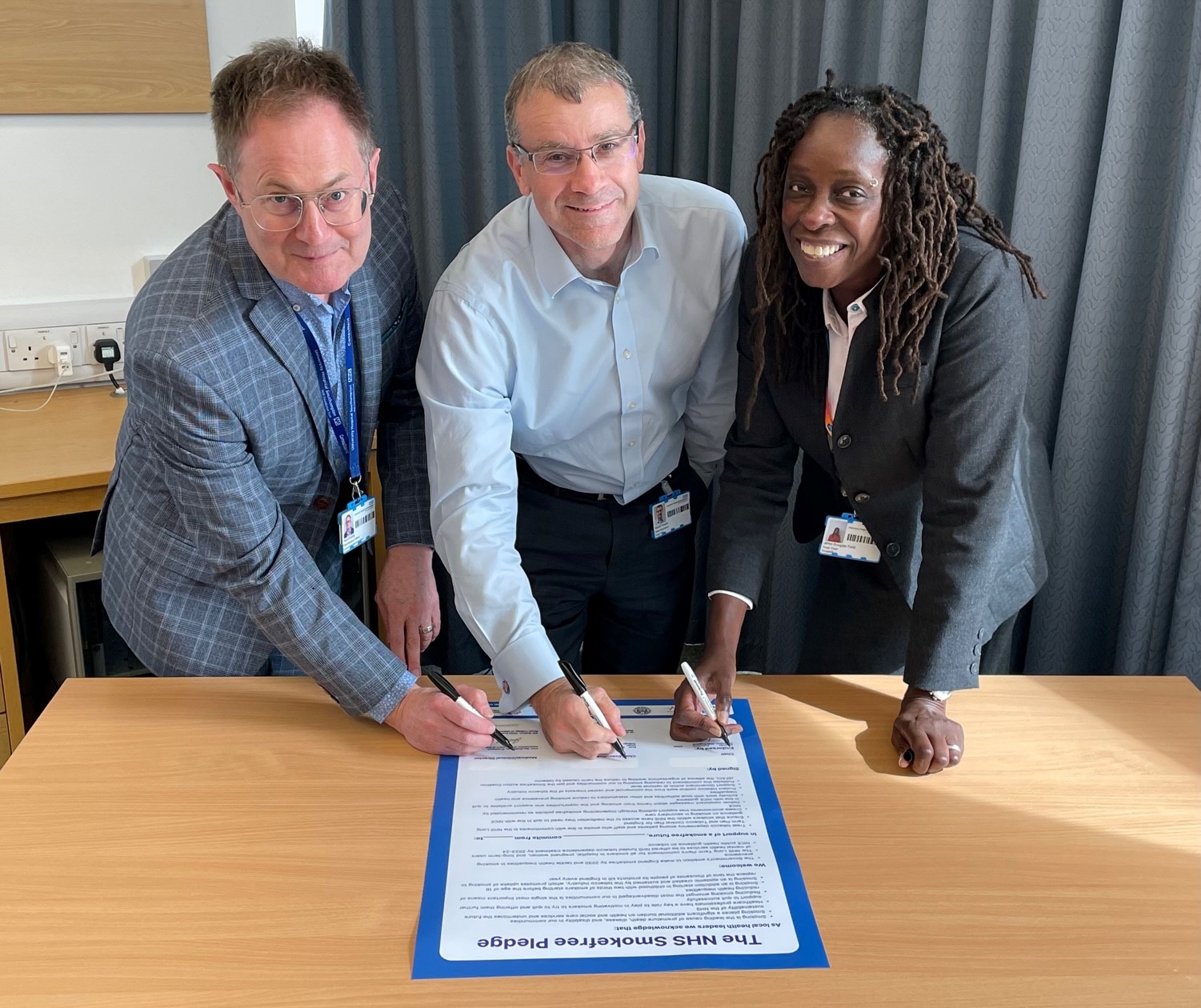 Chief medical officer Paul Grundy, chief executive David French and UHS chair Jenni Douglas-Todd signing the smoke-free pledge