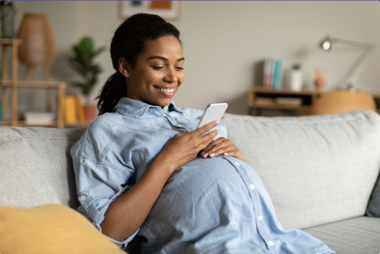 A pregnant woman using her phone.